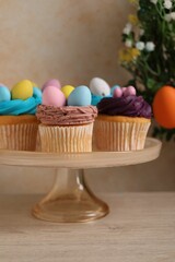 Tasty cupcakes with Easter decor on wooden table