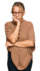 Middle age blonde woman wearing sweater and glasses thinking looking tired and bored with...