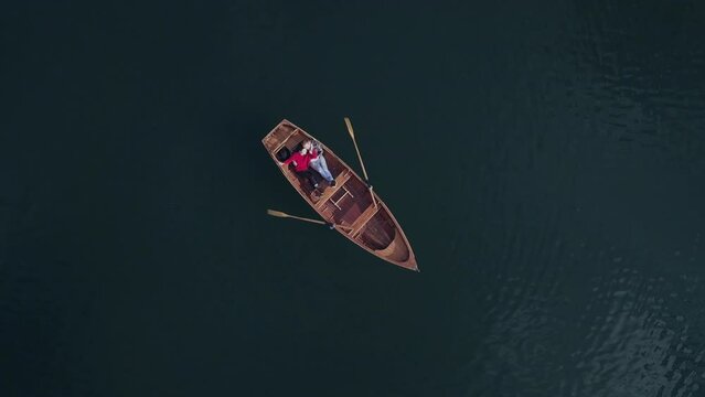 Young couple in love together in romantic boat trip. Drone shot from the top. Lovers paddle on beautiful lake. Travel, date and adventure concept. Active vacation weekend. Tourism and sport canoeing.