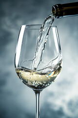 Filling a wine glass with white wine  - obrazy, fototapety, plakaty