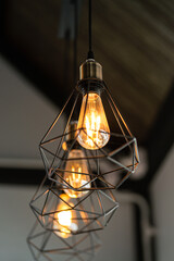 Classic style lightbulb ceiling lamp with iron cage glowing in orange light shade. Interior...