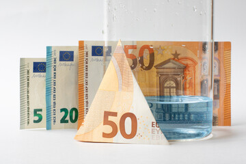Economy. Increasing the cost of water is a concept .Jar with small amount of water next to euro banknotes