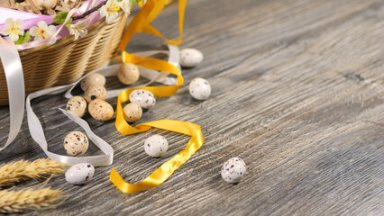 Eggs in basket decorated with ribbons and flowers. Easter celebration concept.