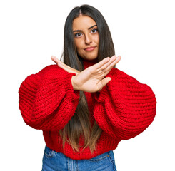 Beautiful hispanic woman wearing casual clothes rejection expression crossing arms and palms doing negative sign, angry face