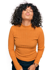 Young hispanic woman wearing casual clothes looking at the camera blowing a kiss on air being lovely and sexy. love expression.