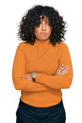 Young hispanic woman wearing casual clothes skeptic and nervous, disapproving expression on face with crossed arms. negative person.