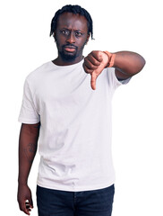 Young african american man with braids wearing casual white tshirt looking unhappy and angry showing rejection and negative with thumbs down gesture. bad expression.