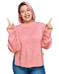 Hispanic woman with pink hair wearing casual winter sweater smiling confident pointing with fingers to different directions. copy space for advertisement