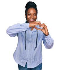 Young african american woman wearing casual clothes smiling in love doing heart symbol shape with hands. romantic concept.