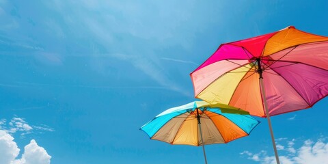 two colorful beach umbrellas against the blue sky, summer background