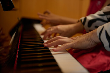 Closeup female pianist hands creating the rhythm of melody, touching white and black keys of piano...