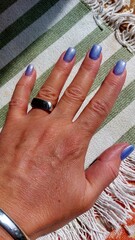Hand with ring and purple nail polish. Beauty fashion photo.