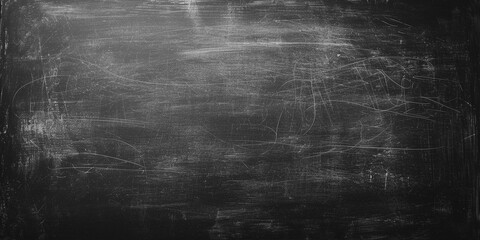 Blank blackboard or chalkboard texture backdrop with copy space. Close up of empty dirty school black chalkboard. Blackboard background with chalk smudge texture in wide web banner format, dark grey