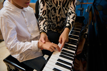 Close-up shot of a music teacher, female pianist explaining correct hands and finger position on...