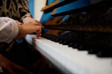 Side view hands of musician pianist teacher maestro teaching a child boy the true position of...