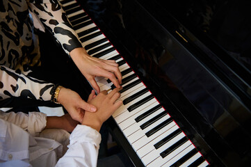 Top view hands of musician pianist teacher maestro teaching a child boy the true position of...