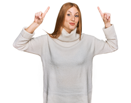 Young irish woman wearing casual winter sweater smiling amazed and surprised and pointing up with fingers and raised arms.