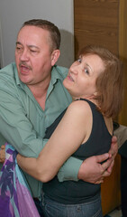 Fototapeta premium Elderly pair dancing during karaoke singing at home.