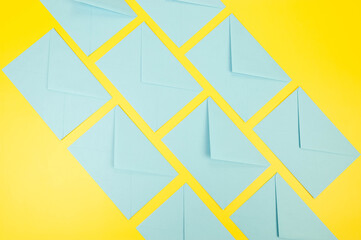 Top view of light blue envelopes on yellow background. Post flat lay. Copy space.