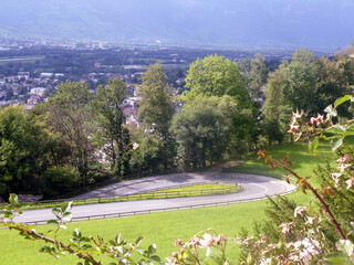 A winding road descends from the hill to a small, beautiful village behind the park