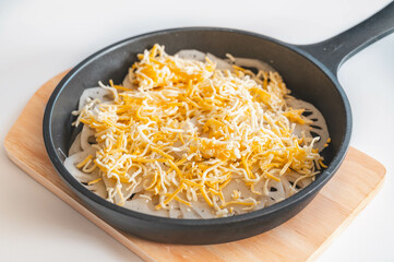 スキレットに敷いた蓮根に乗せたチーズ