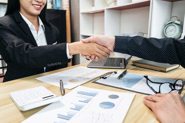 Two businesspeople shaking hands in a business meeting - 775179692