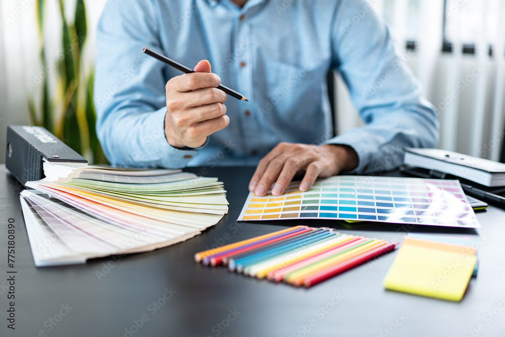 Poster Young creative graphic designer working on color selection and drawing on graphics tablet at workplace, Color swatch samples chart for selection coloring in inspiration to create new collection