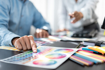 Team of creative graphic designer working on color swatch samples chart for selection coloring in inspiration to create new collection at workplace - obrazy, fototapety, plakaty