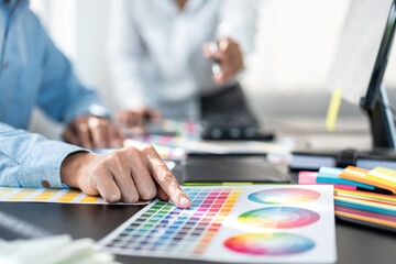 Two creative graphic designer team working on color selection and drawing on graphic tablet, Color swatch samples chart for selection coloring in inspiration to creativity at workplace - 775181037