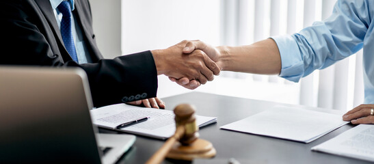 Handshake after good cooperation, Two people shaking hands after discussing contract agreement on front a judge's gavel - 775183489
