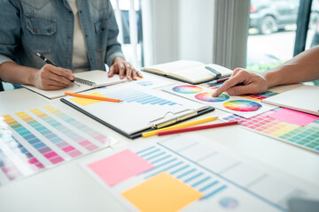 Team of creative graphic designer working on color swatch samples chart for selection coloring in...
