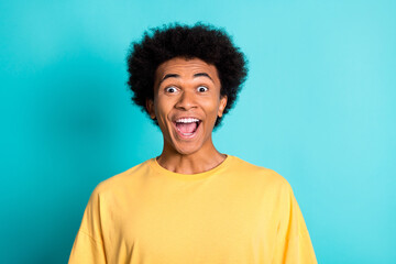 Fototapeta na wymiar Portrait of overjoyed ecstatic man with afro hairstyle wear oversize t-shirt staring at awesome sale isolated on teal color background