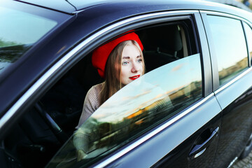 girl in a red beret in a car, concept travel and business trip
