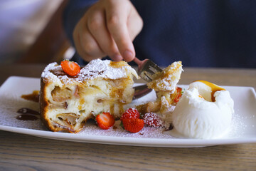 Person Cutting Into Dessert on Plate