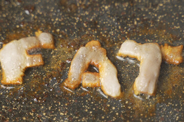 Golden Melted Cheese Letters Spelling FAT on a Pan