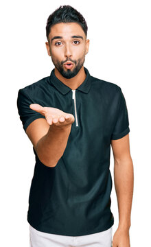 Young man with beard wearing sportswear looking at the camera blowing a kiss with hand on air being lovely and sexy. love expression.