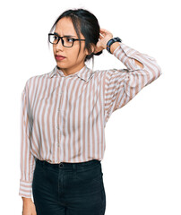 Young hispanic girl wearing casual clothes and glasses confuse and wondering about question....