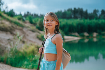 Young girl looking back on a lakeside.