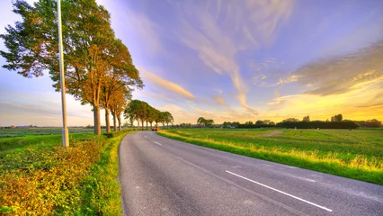 Foto auf Leinwand A bend in the road. Country-side Holland at sunset. © Alex de Haas