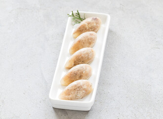 Jellied meat in the shape of a quenelle. On a plate. Close up. Light background