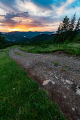 Fototapeta na wymiar Magical dawn in the Carpathians, a road for tourists in the foreground.
