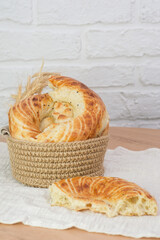 Asian flatbread in a basket on wooden table on white bricks background, top view.