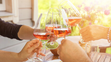 Obraz premium Family of different ages people cheerfully celebrate outdoors with glasses of rose wine or cider