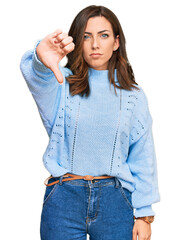 Young brunette woman wearing casual winter sweater looking unhappy and angry showing rejection and negative with thumbs down gesture. bad expression.