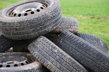 Umweltverschmutzung, illegal entsorgte Reifen auf einer Wiese