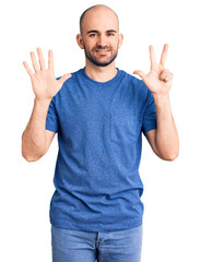 Fototapeta premium Young handsome man wearing casual t shirt showing and pointing up with fingers number eight while smiling confident and happy.