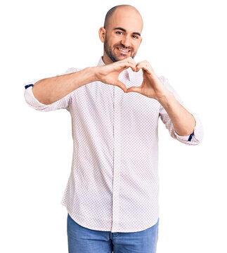 Young handsome man wearing elegant shirt smiling in love doing heart symbol shape with hands. romantic concept.