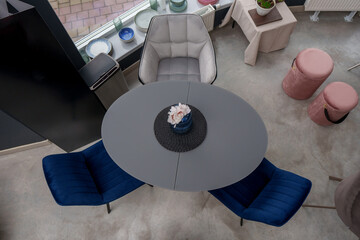 Gray wooden table combined with blue wooden chairs with soft fabric upholstery. There is a blue...