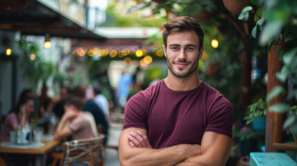 A man in a red shirt is standing in front of a restaurant with a smile on his face