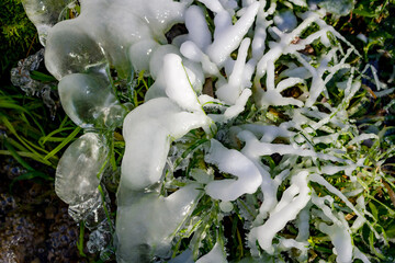 Beautiful icy spring in sunny day, close-up ice growths